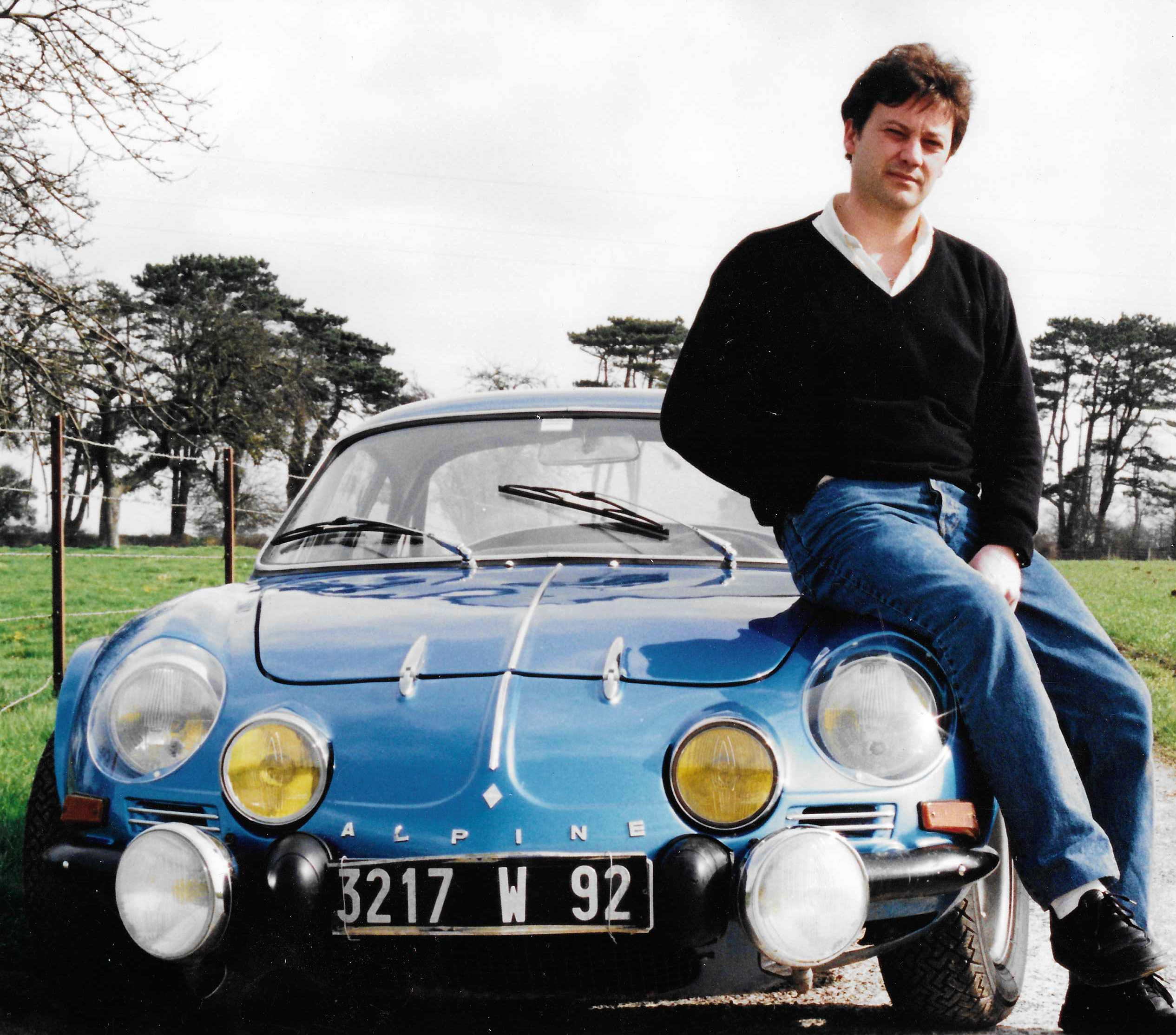 Eddy Harivel appuyé sur son Alpine A110 bleue